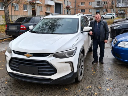 Андрей у белого Chevrolet Tracker в день выдачи в Луговом
